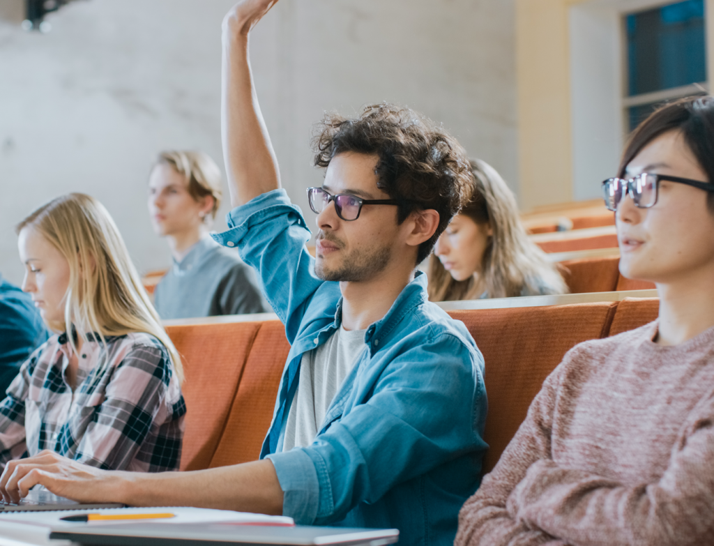 College student putting up hand in class